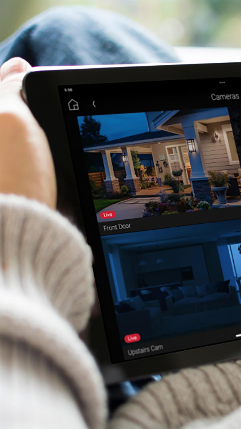 Person holding tablet displaying live security camera feed of front door