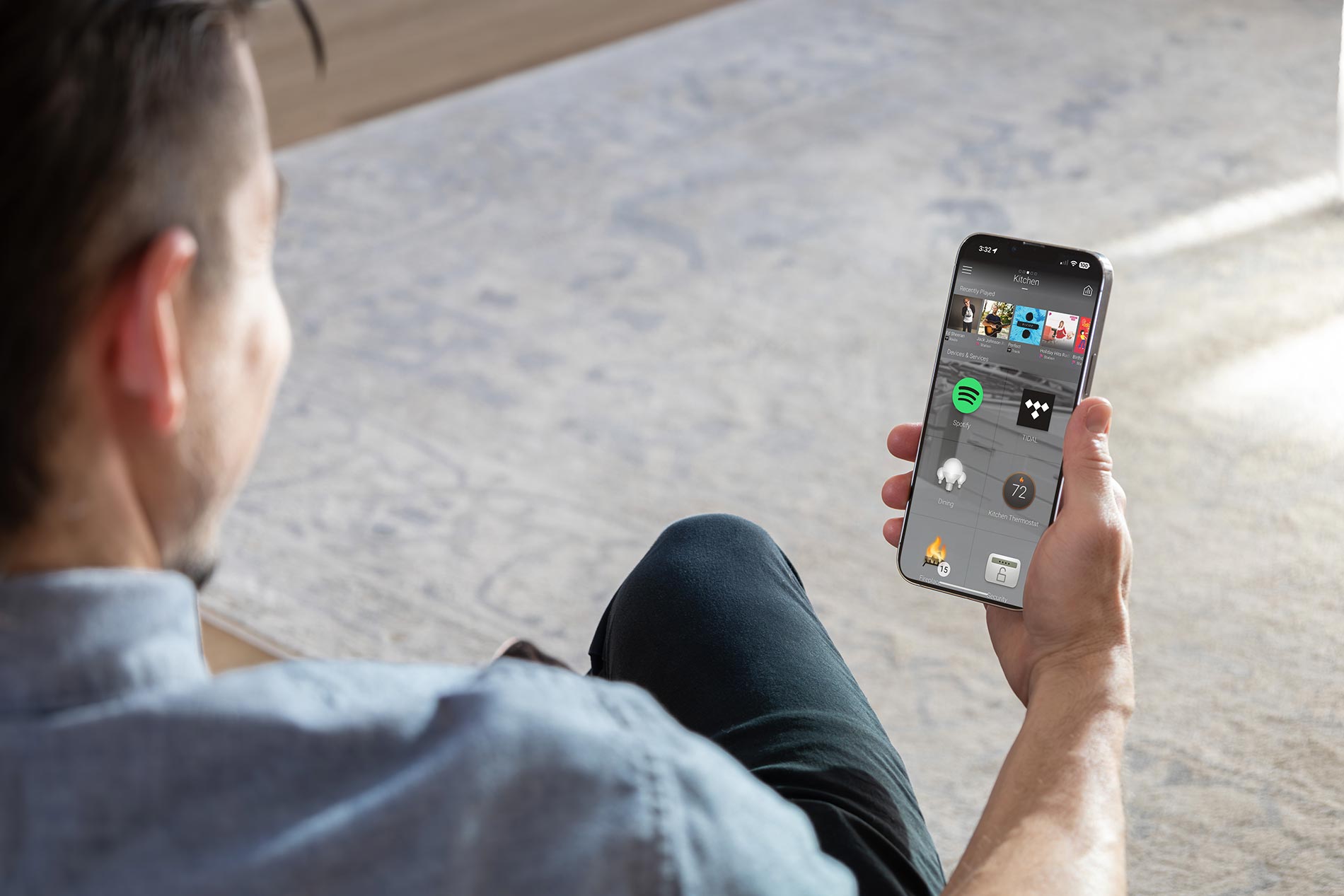 Person holding smartphone showing smart home control app interface